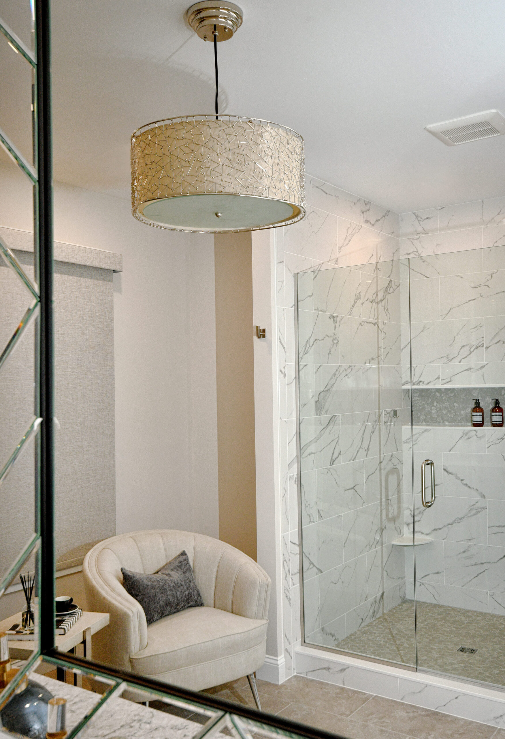 Sitting area and decorating in master bathroom with standing shower by Valerie Ruddy.